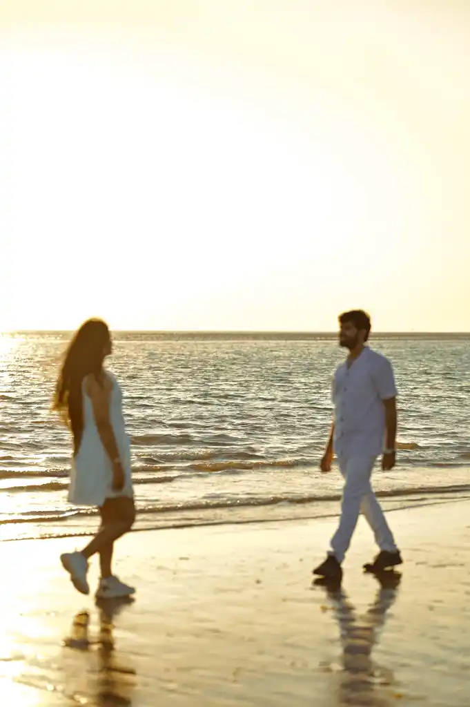 Couple walking on a beach at sunset